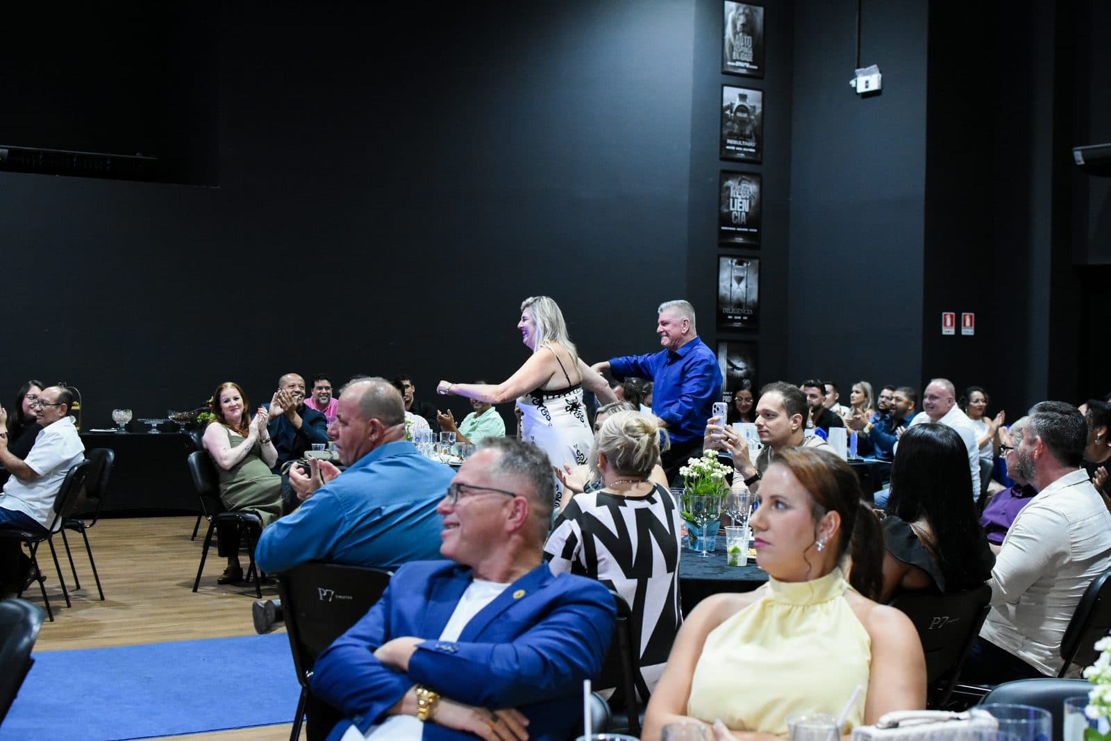 Plateia de empresários sentada em auditório durante evento