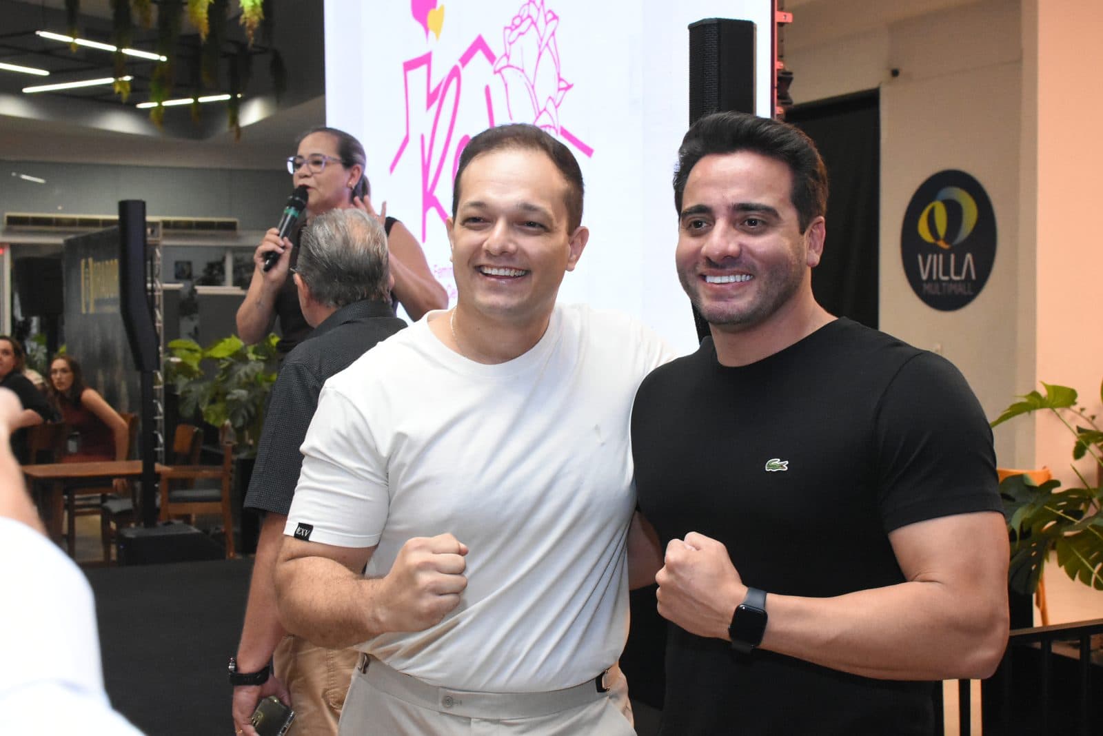 Dois participantes sorrindo e posando para foto em evento