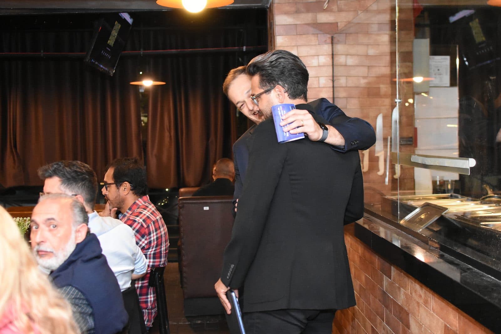 Dois participantes se abraçando durante evento