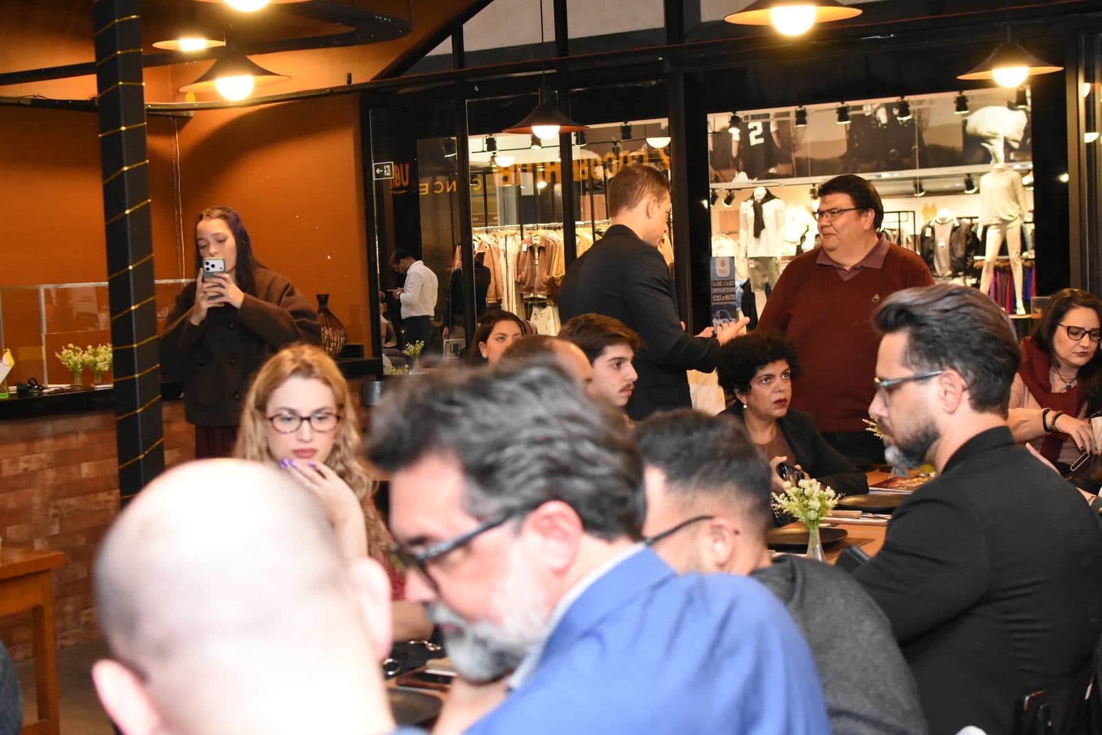 Participantes à mesa durante evento em restaurante