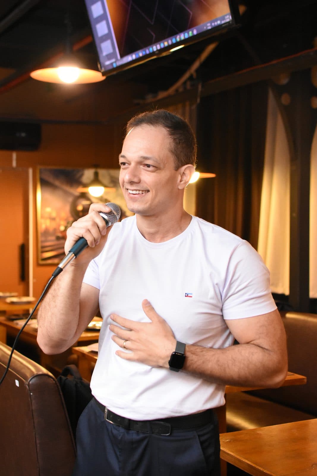 Palestrante de camiseta branca apresentando para o grupo